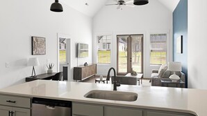 Une cuisine moderne équipée d’un lave-vaisselle, d’un évier et d’un coin repas avec une table et des chaises.