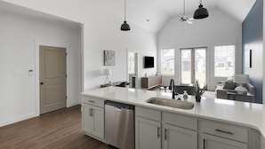 A modern kitchen with a large island, stainless steel appliances, and a view to the outside. - Landing | Amazing 2BD, Clubhouse, Gym (Athens)