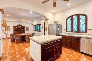 A kitchen with a central island, wooden cabinets, a built-in oven, and a window with a tree view. - Oceanview Getaway  Salt Pool (SAN FRANCISCO)