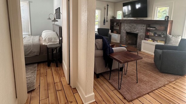 Amplia sala de estar con chimenea, televisor y zona de estar con una mesa de centro.