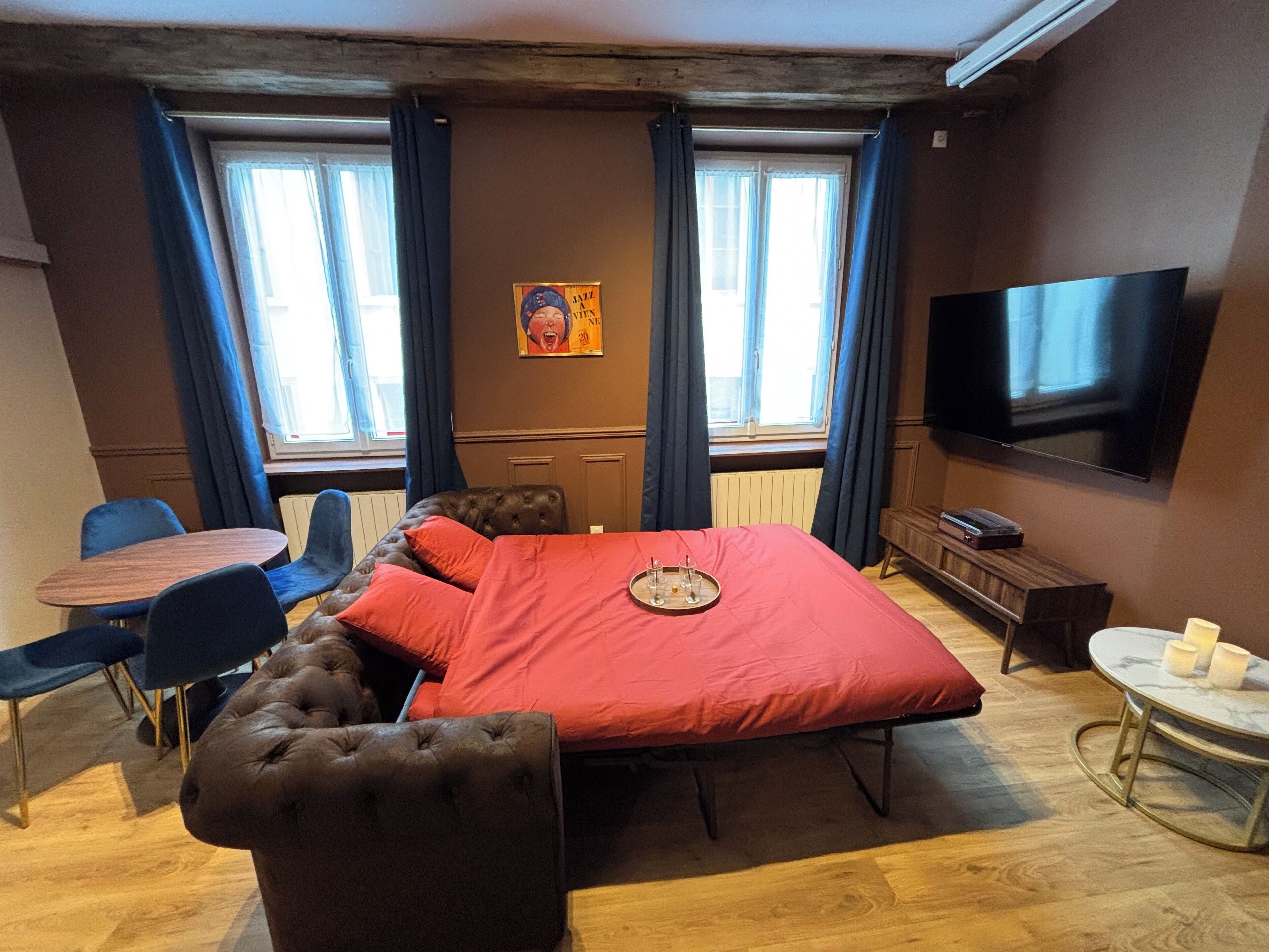 Habitación de hotel con una cama grande, televisión, escritorio y una silla.
