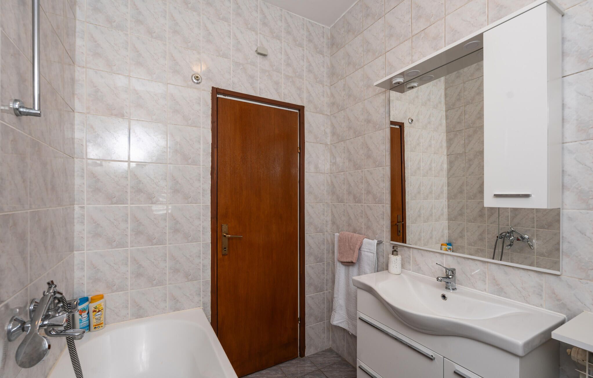 Une salle de bain moderne avec une baignoire, un lavabo et un miroir.