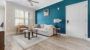 Un salon comprenant un canapé, un fauteuil, une table basse et une lampe.