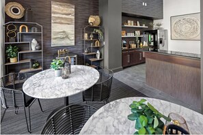 A modern kitchen with a marble island, dark wood cabinets, and a built-in refrigerator.