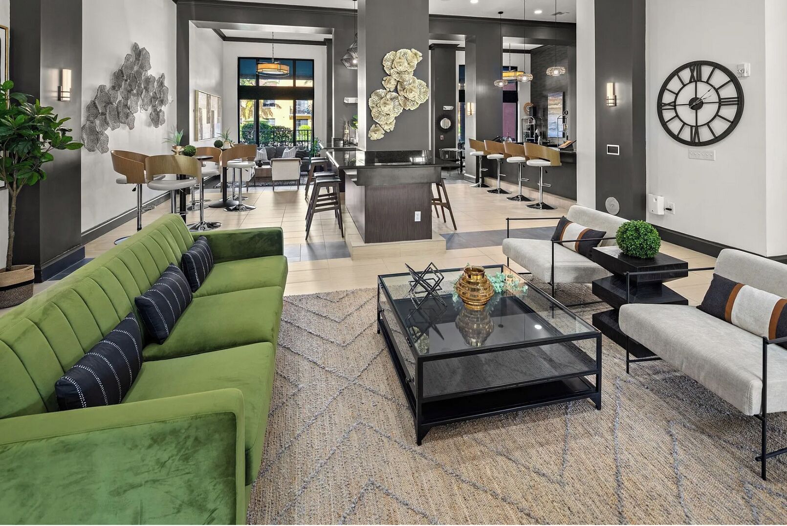 A modern hotel lobby with a green sofa, a coffee table, and a bar area.