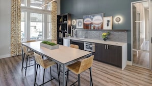 A modern kitchen with a dining area, featuring a large window, dark wall, and contemporary design elements. - Landing | Spectacular 1BD, Gym, Clubhouse (Rockwall)