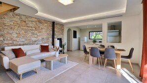 Uma sala de estar moderna com um sofá seccional, uma mesa de centro e um espaço de jantar com cadeiras e mesa.