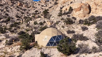 A dome-shaped structure in a rocky, desert-like environment with sparse vegetation.