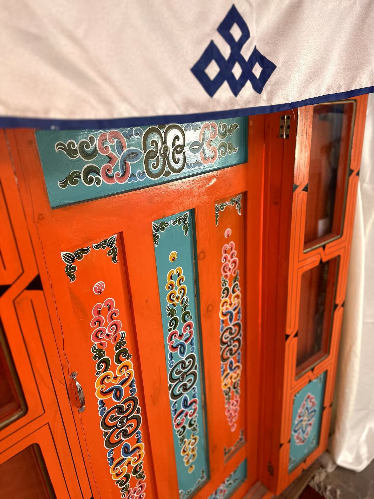 A door with intricate decorative patterns and a blue and orange color scheme.