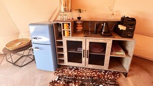 A compact kitchenette with a refrigerator, coffee maker, and storage cabinets. - Native American Bison Tipi (Teasdale)