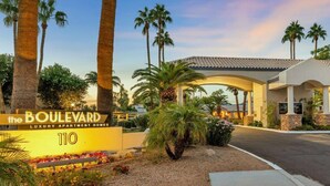 De entree van The Boulevard Luxury Apartment Homes, met palmbomen en een overdekte doorgang.