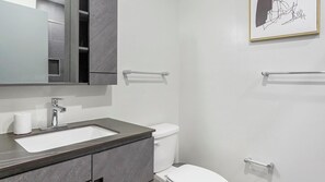 A modern bathroom with a large mirror, a sink, a toilet, and towel racks. - Landing | Spectacular 2BD, Gym (Philadelphia)