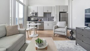 A modern living room with a sofa, a coffee table with a plant, and a TV.