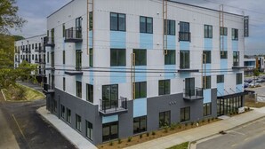 Ein mehrstöckiges Gebäude mit modernem architektonischen Design, das Balkone und große Fenster aufweist.