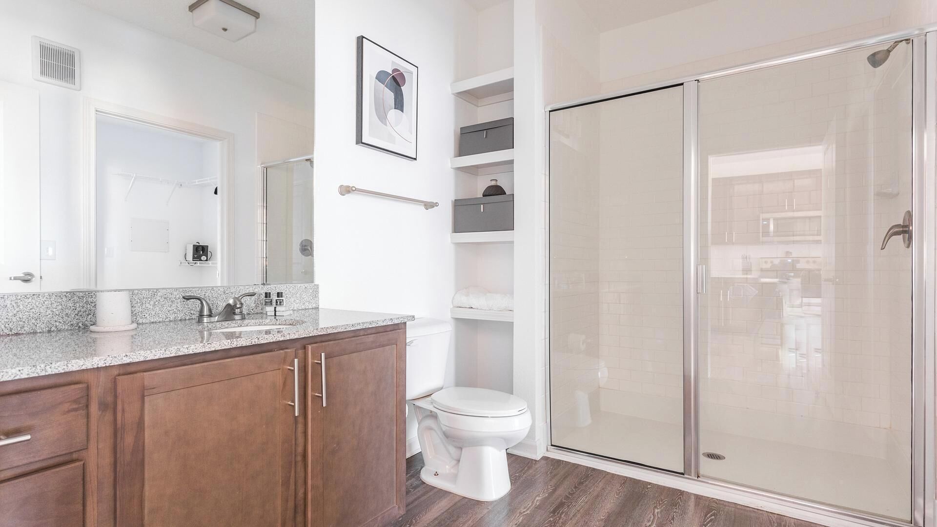 A modern bathroom with a shower, toilet, and vanity.