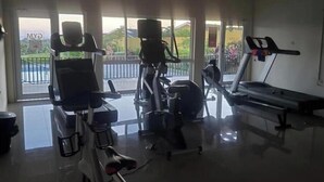 A gym with cardio machines, a bench, and a treadmill. - Spacious two bedroom home with ocean view, pool and tennis court. (Florence Hall Village)
