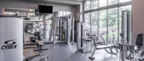 A gym with various exercise equipment, large windows, and a Cyrex machine.