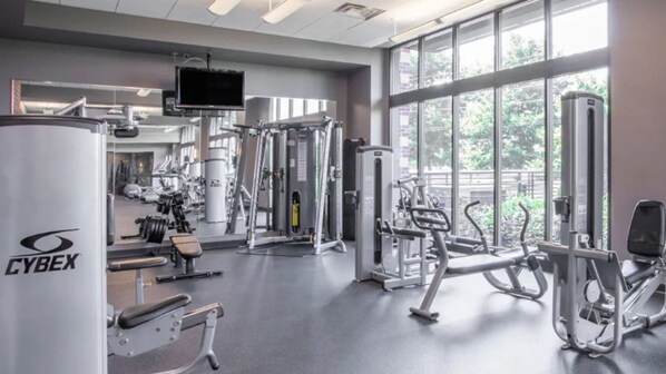 A gym with various exercise equipment, large windows, and a Cyrex machine.