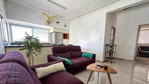 Un salon moderne avec un canapé violet, une petite table basse et une plante.