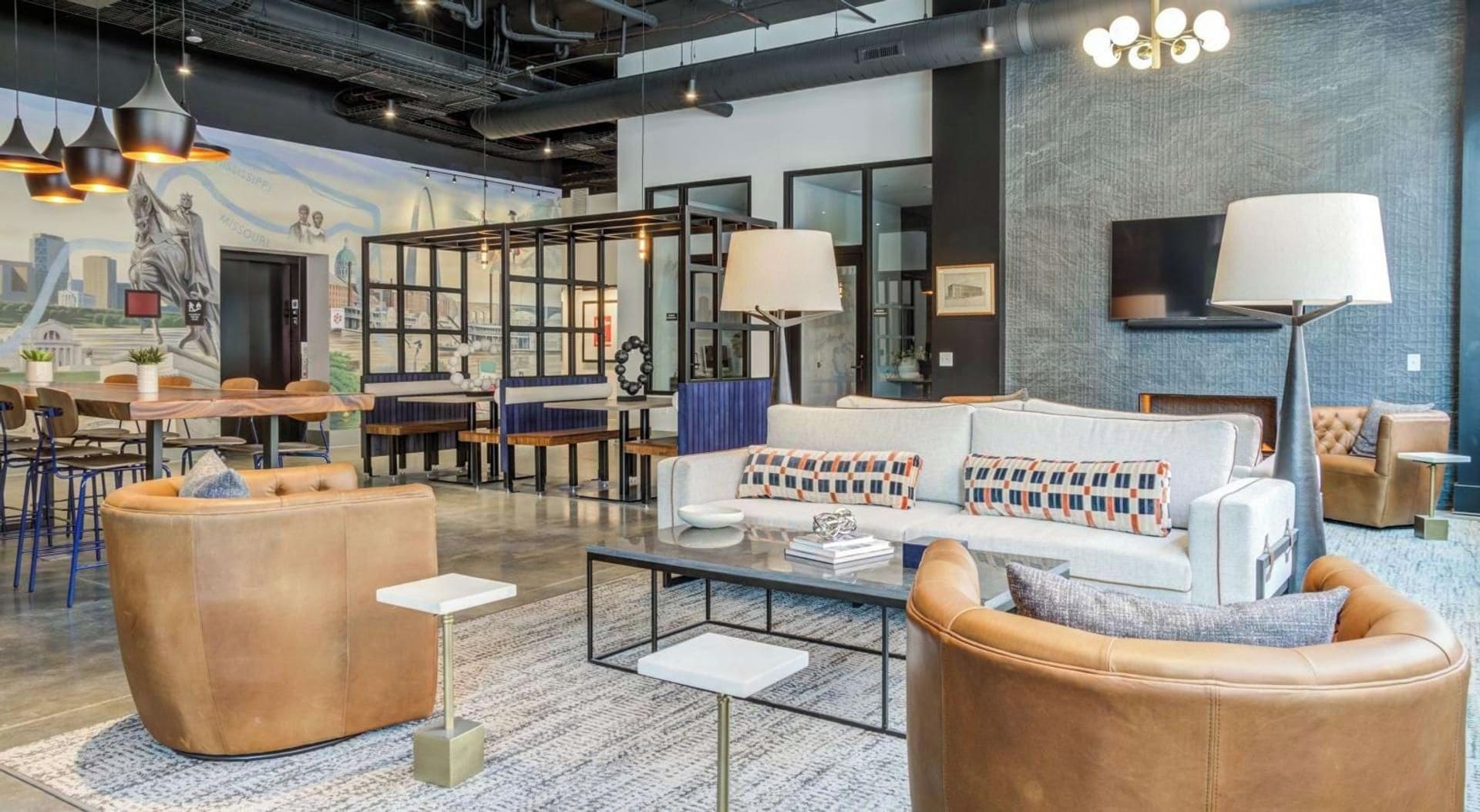 A modern lounge area with leather sofas, a coffee table, and pendant lighting.