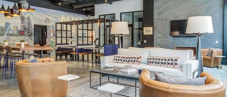 A modern lounge area with leather sofas, a coffee table, and pendant lighting.