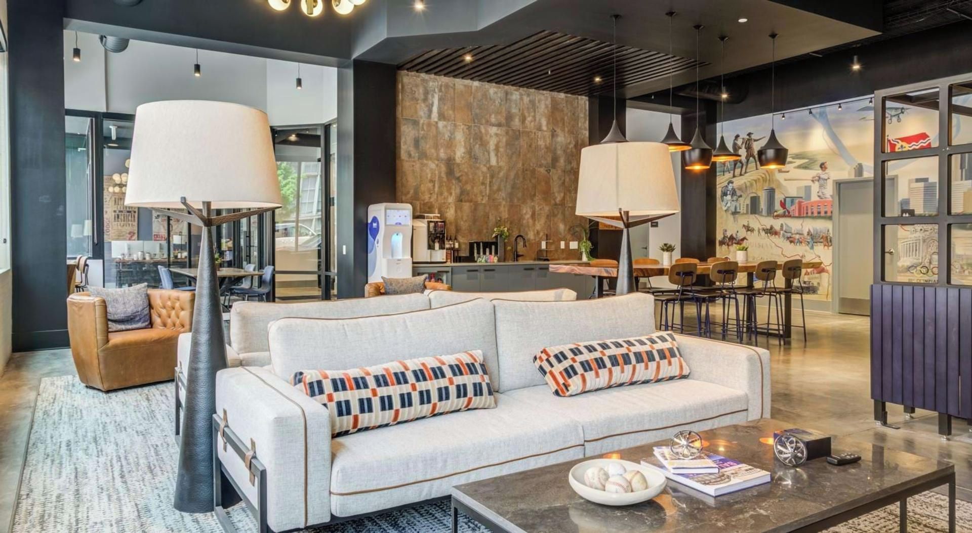 A modern hotel lobby with a sofa, coffee table, and dining area.