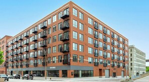 A multi-story building with a brick facade, large windows, and balconies.