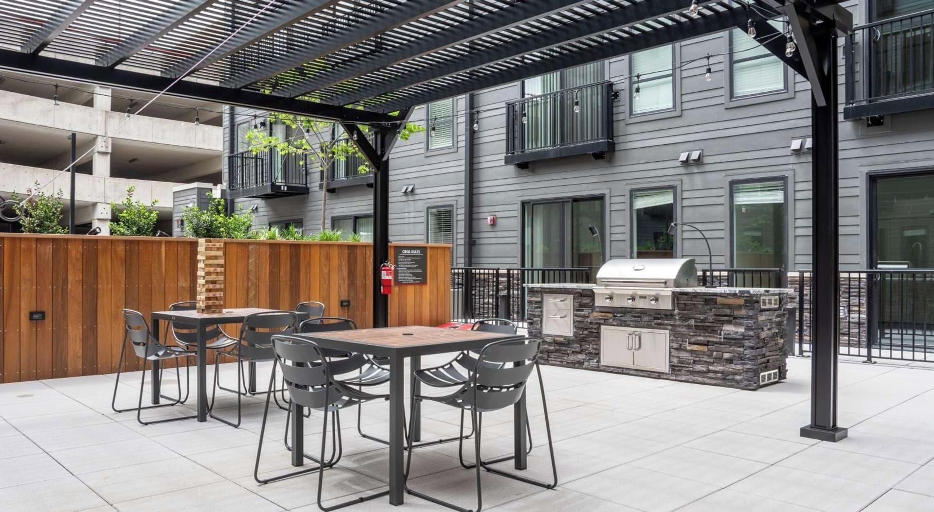 Eine Außenpatio mit Grill und Sitzgelegenheit.