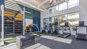 A gym with exercise equipment, a treadmill, and a weight rack.