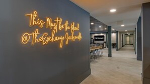 A modern interior with a neon sign reading "This Must be the Place @ The Exchange Jacksonville". - Landing | Stylish 2BD, Gym, Pool (Jacksonville)