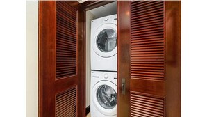 A wooden wardrobe with two white front-loading washing machines inside. - Partial Ocean View 1BR +Queen Sleeper Sofa, Prime Location 
Family Friendly (Kapaa)
