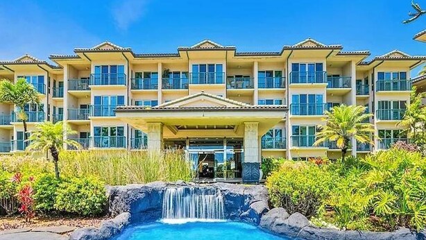 A hotel with a swimming pool, a waterfall, and a well-maintained garden. - Partial Ocean View 1BR +Queen Sleeper Sofa, Prime Location 
Family Friendly (Kapaa)