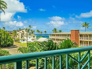 A resort with multiple buildings, a pool, and palm trees.