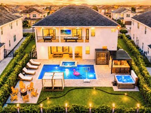 A two-story house with a swimming pool, outdoor seating, and a hot tub. - 11BR Disney Golf Estate | Trackman, Theater, Spa (Kissimmee)