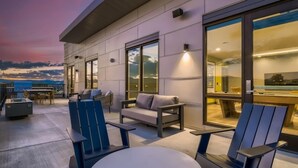 An outdoor seating area with chairs and a table, overlooking a pool and a sunset view. - Landing | Chic Studio in Fort Collins (Fort Collins)
