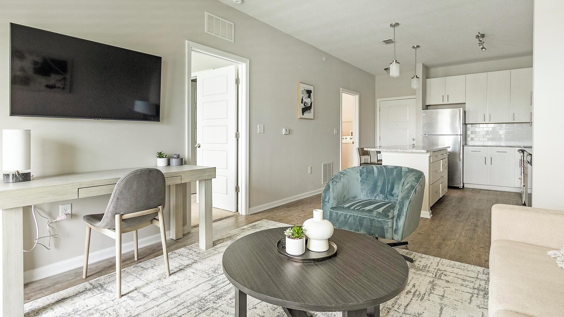 A modern apartment with a dining area, a living room, and a kitchen.