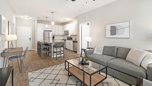 A modern apartment with a dining area, kitchen, and living room. - Landing | Amazing 2BD, Clubhouse, Pool (Wesley Chapel)