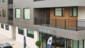 A modern building with a grey facade, a balcony with a black railing, and the address "1510 Bellevue" visible. - Landing | Amazing 1BD, Rooftop Lounge, Game Room (Richmond)