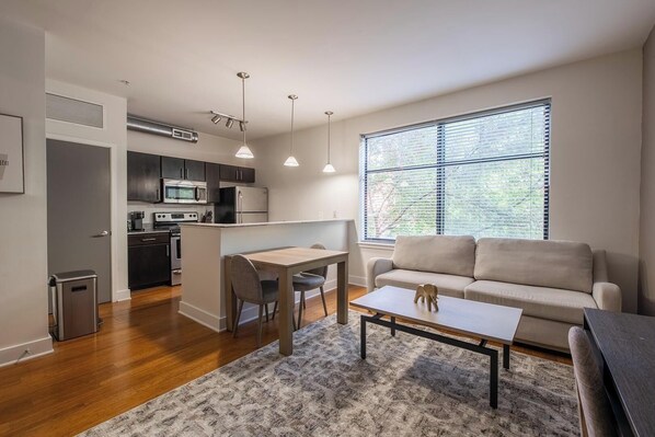 A modern apartment with a kitchen, dining area, and living room.
