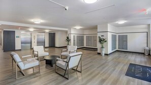 A modern reception area with a seating arrangement, lockers, and a security camera.