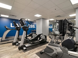 A gym with treadmills, elliptical machines, and weight equipment.
