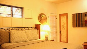 Une chambre à coucher avec un lit, une fenêtre, une horloge murale et une porte.