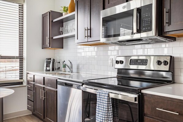 Una cocina moderna con electrodomésticos de acero inoxidable, lavavajillas y horno empotrado.