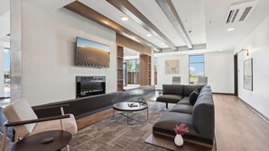 Una sala de estar moderna con un televisor de pantalla plana grande, un sofá, una mesa de centro y una chimenea.