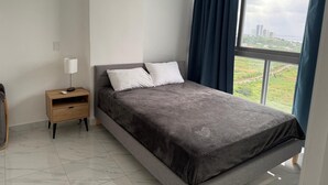 A modern bedroom with a large bed, a nightstand, and a view of a cityscape through a window.