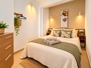 A modern bedroom with a bed, bedside tables, a hanging plant, and wall-mounted lighting. - 4 Manolo Pris Two Bed Rooms (El Pris)