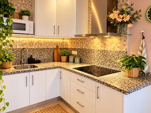 A modern kitchen with white cabinets, granite countertops, a built-in microwave, and a stainless steel range hood. - 4 Manolo Pris Two Bed Rooms (El Pris)