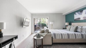 Ein Schlafzimmer mit einem Bett, Nachttischen, einem Schreibtisch und einem Stuhl.