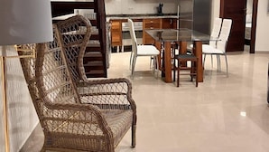 Una cocina moderna con extractor de acero inoxidable, armarios de madera y un comedor con sillas de mimbre.