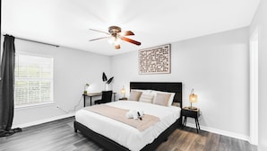 A modern bedroom with a bed, bedside tables, a ceiling fan, and a window with blinds. - • NEW • Walk to AT&T Stadium  and Globe Life Field • Rangers • Free parking (Arlington)